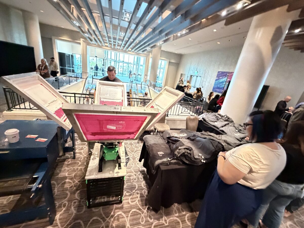 Screen printing carousel and folded shirt stacks set up in a conference hotel lobby